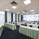 A spacious meeting room with neatly arranged tables and chairs, ready for a conference or seminar.