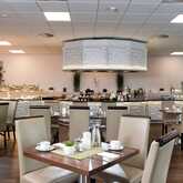 A modern breakfast restaurant features neatly set tables and a well-stocked buffet against a backdrop of elegant decor.