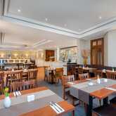 A spacious, elegant restaurant interior features neatly arranged tables with vases and soft lighting.