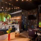 Ein stilvoll eingerichteter Frühstücksraum mit gedecktem Tisch, Buffet und dekorativen Lichterketten an der Decke.
