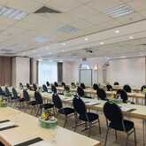 The spacious meeting room is set up with tables, chairs, and presentation equipment, ready for a conference in Herkules A+B.