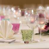 Elegant table setting with folded napkins, wine glasses, and vibrant flowers creating a festive atmosphere.