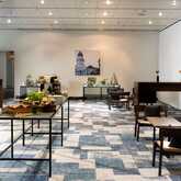 A modern conference room is set up with tables of refreshments and coffee for a relaxing coffee break.