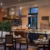 The hotel breakfast buffet is elegantly set with a variety of pastries, cereals, and beverages, surrounded by stylish decor.
