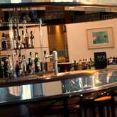 Eine elegante Hotelbar mit einer Vielzahl von Spirituosenflaschen und stilvollen Barhockern lädt zum Verweilen ein.