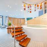 Ein luxuriöser Wellnessbereich mit einem großen, einladenden Jacuzzi und entspannenden Liegestühlen bietet Ruhe und Entspannung.