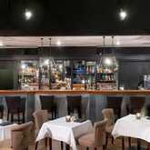 A stylish hotel bar features elegant seating, a well-stocked counter, and ambient lighting creating a welcoming atmosphere.