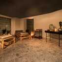 A serene spa lounge with bamboo loungers, ambient lighting, and decorative vases creates a relaxing atmosphere.