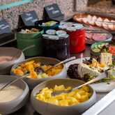 Ein vielfältiges Buffet mit frischem Obst, Käse und Aufschnitt lädt zur Selbstbedienung ein.