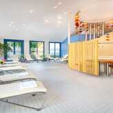 A serene wellness area features lounge chairs, potted plants, and a jacuzzi surrounded by artistic ceiling decor.