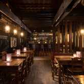 A cozy hotel bar features rustic wooden tables, warm lighting, and a well-stocked counter for an inviting ambiance.