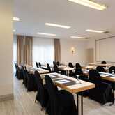 A well-lit meeting room with neatly arranged tables and chairs, ready for a conference in Wendelstein.