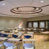 An empty conference room with circular seating arrangement and modern lighting awaits a meeting at Europasaal.