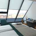 Ein modernes Hotelzimmer im Excelsior Hotel Nürnberg Fürth mit Panoramafenster und elegantem Interieur.