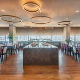 Ein elegantes Restaurant mit modernen Hängelampen und gedeckten Tischen strahlt eine einladende Atmosphäre aus.