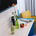 Ein moderner Schreibtisch in einem Doppelzimmer mit Getränk, Zeitschrift und Blume sorgt für eine einladende Atmosphäre.