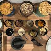 Verschiedene Cerealien und Nüsse sind auf einem kleinen Buffet arrangiert und laden zum Frühstück ein.