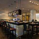 Elegante Hotelbar mit moderner Einrichtung und gut bestückter Theke, bereit für Gäste in stilvollem Ambiente.