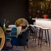 Moderne Lobby mit stilvollen Sitzgelegenheiten und beleuchtetem Tresen, ideal für entspannte Gespräche.
