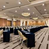 A spacious Salzburg conference room features neatly arranged tables and chairs, ready for a large meeting or event.