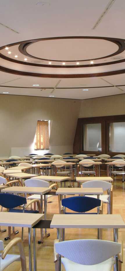 An empty conference room with circular seating arrangement and modern lighting awaits a meeting at Europasaal.