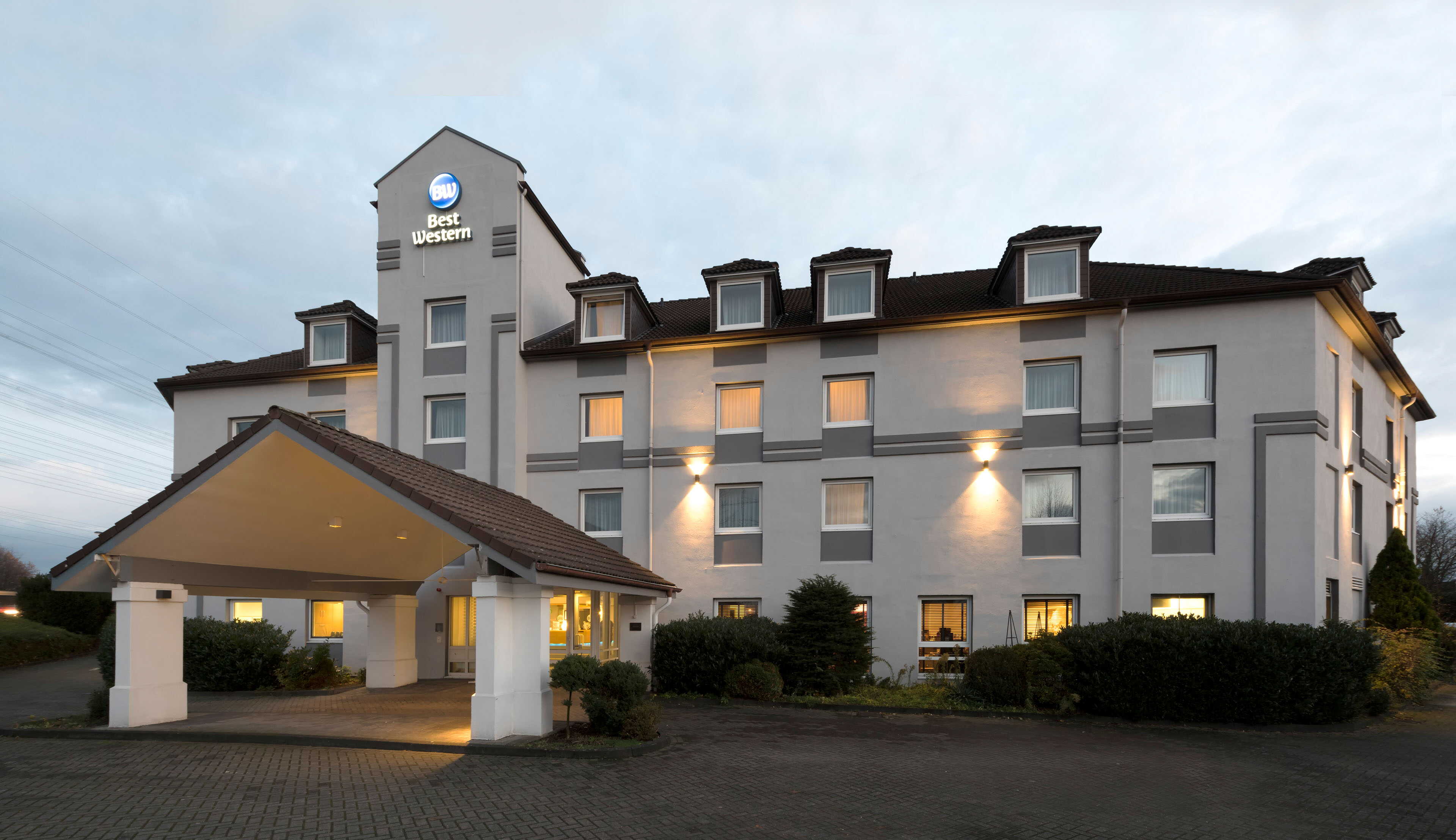The ibis Styles hotel features stylish exterior signage and a welcoming entrance at dusk.