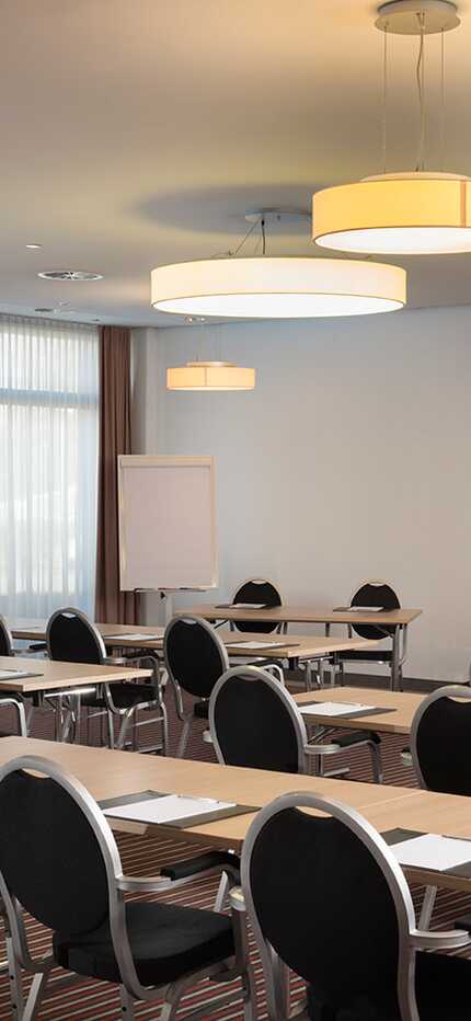 A well-lit meeting room, set up classroom-style with rows of tables and chairs, awaits attendees in Jupiter I.