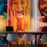 A vibrant breakfast restaurant features colorful wall art and a long table with a laptop and breakfast setup.