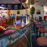 Eine elegante Hotelbar mit geschwungener Theke, stilvoller Beleuchtung und einer Vielzahl von Spirituosen.
