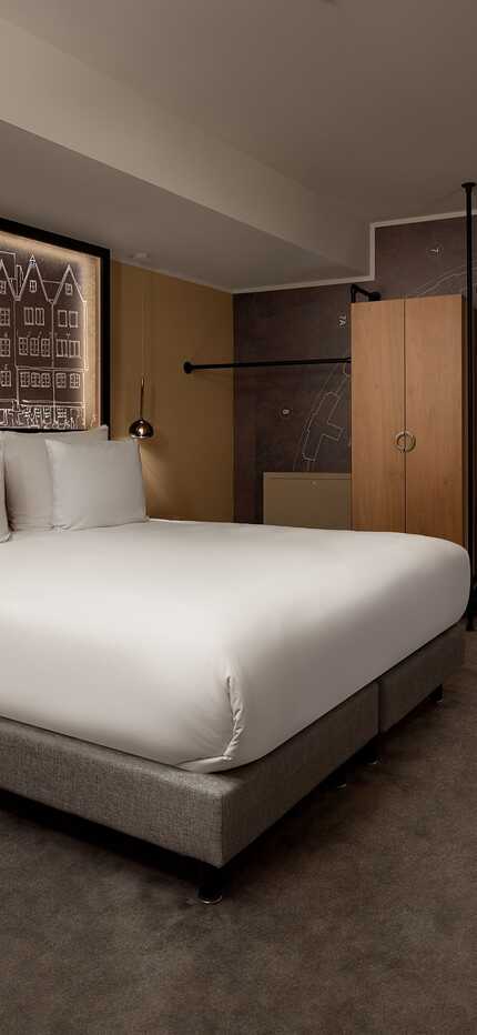 A modern bedroom features a cozy bed, soft lighting, and architectural wall art, evoking a wasserturm ambiance.