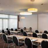 A well-lit meeting room, set up classroom-style with rows of tables and chairs, awaits attendees in Jupiter I.