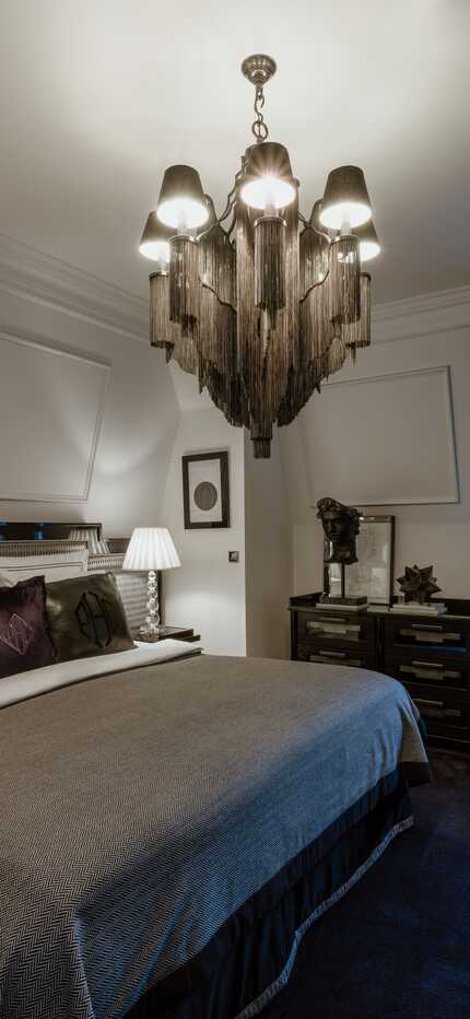 Eine elegante Premium Junior Suite mit luxuriösem Bett, stilvoller Beleuchtung und einem Fenster mit schweren Vorhängen.
