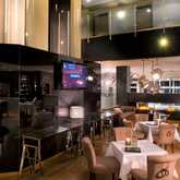 A modern hotel bar features elegant seating, warm lighting, and a cozy fireplace, creating an inviting atmosphere.