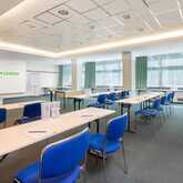 A spacious conference room with blue chairs and tables is set up for a meeting at Wyndham Garden.