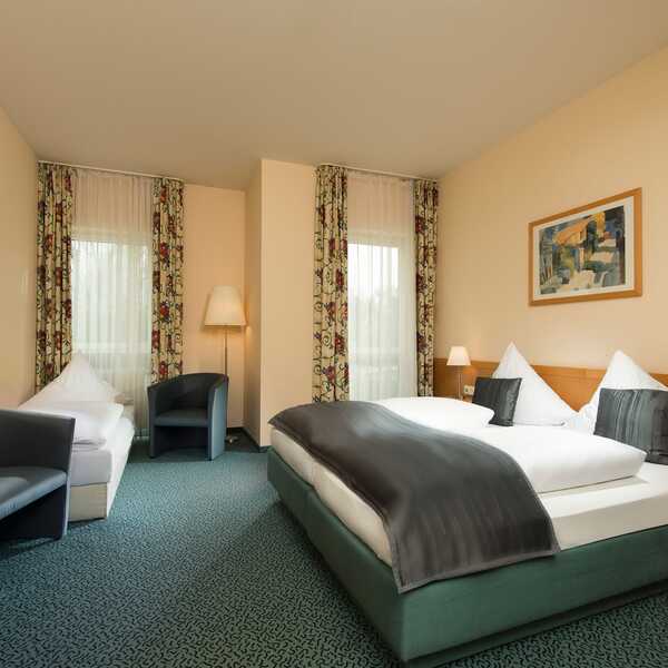 Ein elegantes Doppelzimmer in der Residenz mit gemütlichem Bett, modernen Sesseln und stilvoller Dekoration.