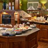 Ein reichhaltiges Frühstücksbuffet mit frischem Obst, Aufschnitt und Gebäck steht in einem eleganten Speiseraum bereit.