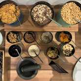 Ein reichhaltiges Müsli-Buffet mit verschiedenen Cerealien, Nüssen und Trockenfrüchten wird appetitlich präsentiert.