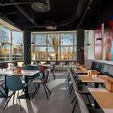 Contemporary breakfast restaurant with colorful chairs and large windows overlooking a scenic outdoor view.
