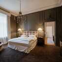 Die luxuriöse Executive Suite im Schloss-Stil zeigt ein elegantes Bett, einen Sessel und kunstvoll verzierte Wände.