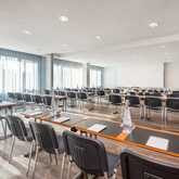 A well-lit classroom at Wittenberg School is set for a seminar with neatly arranged tables, chairs, and bottled water.