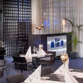 A modern restaurant features elegantly set tables with white napkins and glassware, creating a sophisticated dining atmosphere.