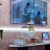 Ein moderner Meetingraum mit Wasserspender, Snacks und einem Willkommensschild. | © Name