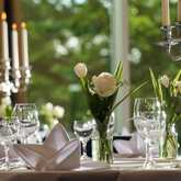 Elegant table setting with white roses and candles creates a sophisticated ambiance for a special event.