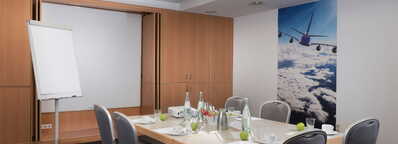 Moderne Besprechungsraum mit Blockbestuhlung, ausgestattet mit Flipchart und inspirierender Wandgestaltung.