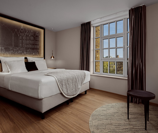 Zimmer mit Doppelbett und Sitzecke im Wasserturm Hotel Cologne | © Hotel Creatives | Sander Baks