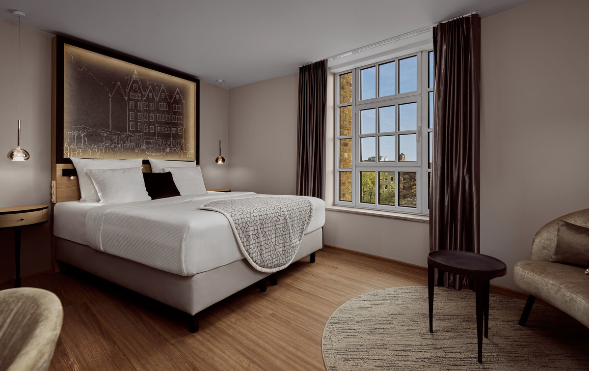 Room with double bed and seating corner at Wasserturm Hotel Cologne | © Hotel Creatives | Sander Baks